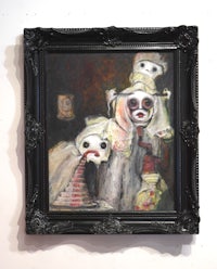 a black framed painting of a clown in a black frame