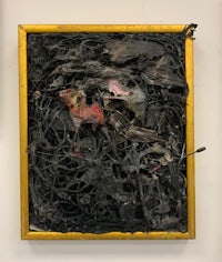 a black and gold framed piece of art on a wall