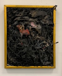 a gold framed piece of art with a black background